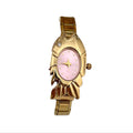 CP STATEMENT gold-tone stainless steel fish-shaped quartz watch with a pink dial and Roman numeral markers.